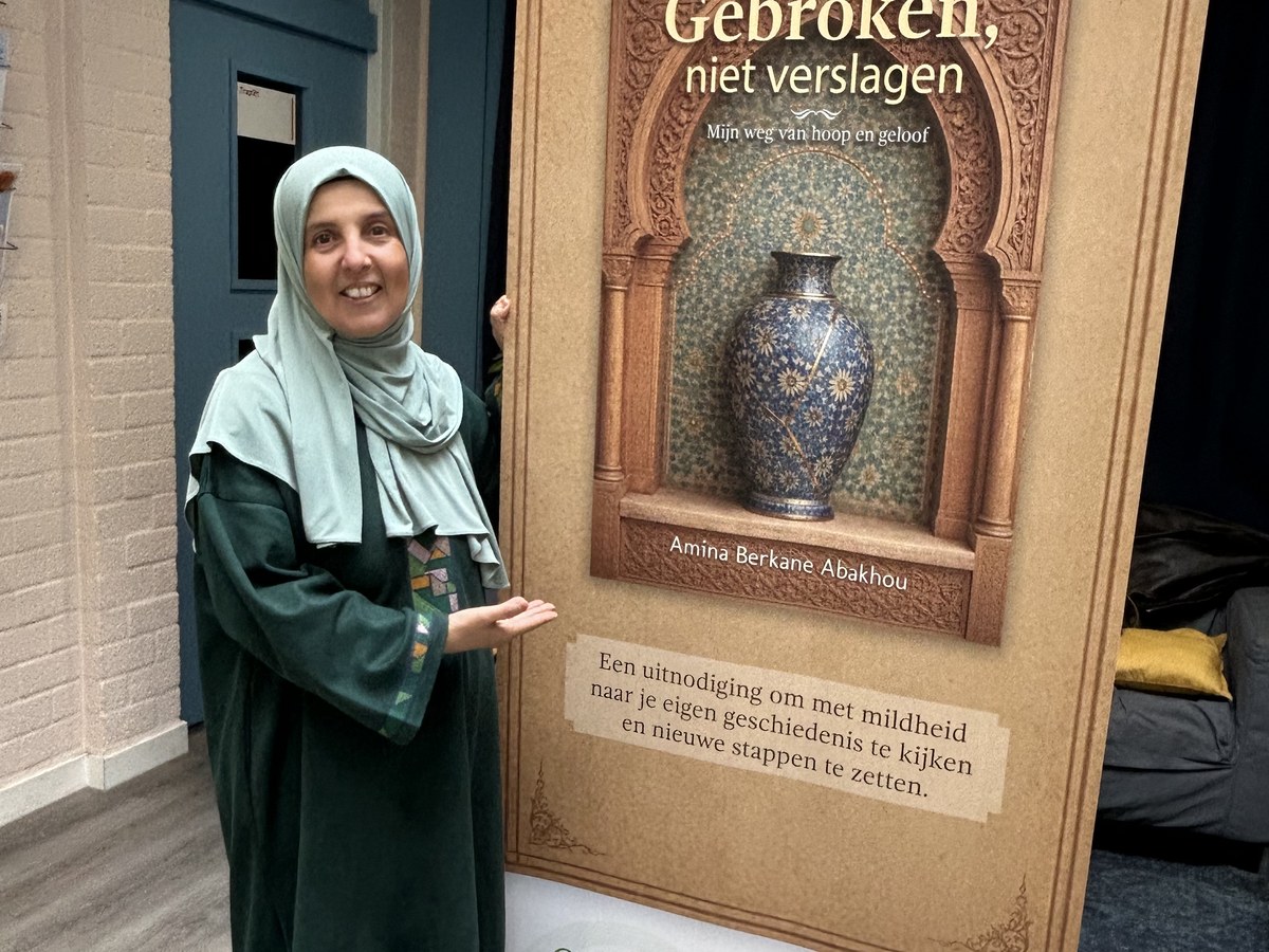 Amina Berkane Abakhou bij de banner van Gebroken, niet verslagen